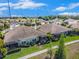 Backyard view of several homes with screened lanais, grassy lawns and tropical trees, plus sidewalks at 13539 Circa Crossing Dr, Lithia, FL 33547