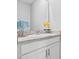 Bathroom vanity with a granite countertop, white cabinets and a decorative flower at 13757 Wineberry Dr, Dade City, FL 33525