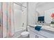 Bright bathroom featuring white cabinetry, granite counters, a bathtub with shower, and a colorful shower curtain at 13757 Wineberry Dr, Dade City, FL 33525