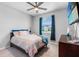 Bedroom with a ceiling fan, window, and bed with colorful bedding, creating a cozy and inviting atmosphere at 13757 Wineberry Dr, Dade City, FL 33525