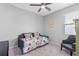Cozy bedroom with a daybed, bright floral bedding, carpeted floors, and a comfortable armchair at 13757 Wineberry Dr, Dade City, FL 33525