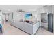Spacious living room featuring an oversized gray sectional, large-screen television, and tile flooring throughout the area at 13757 Wineberry Dr, Dade City, FL 33525