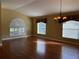 Bright living room features hardwood floors, large windows with shutters, and a decorative chandelier at 1415 Saddle Gold Ct, Brandon, FL 33511