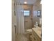 A bathroom with a walk-in shower with white shower curtain and tiled walls at 16106 Bridgedale Dr, Lithia, FL 33547