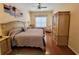 Comfortable main bedroom with a ceiling fan, beautiful hardwood floors, and soft, natural light at 16106 Bridgedale Dr, Lithia, FL 33547