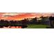 Beautiful sunset reflected in the pond behind a manicured lawn and mature trees at 16106 Bridgedale Dr, Lithia, FL 33547