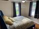 Well-lit bedroom with a ceiling fan, two windows, and a comfortable bed with patterned covers at 1626 27Th N Ave, St Petersburg, FL 33713