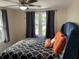 Comfortable bedroom with a ceiling fan, patterned bedding, and grey curtains covering the windows at 1626 27Th N Ave, St Petersburg, FL 33713