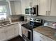 Well-lit kitchen with white cabinets, stainless appliances, and granite countertops at 1626 27Th N Ave, St Petersburg, FL 33713