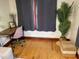 Cozy home office with a wooden desk, pink chair, gray curtains, and a decorative plant at 1626 27Th N Ave, St Petersburg, FL 33713