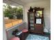 Enclosed porch includes vintage cabinet, decor, and view of the fenced backyard at 1626 27Th N Ave, St Petersburg, FL 33713