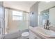 Bathroom with white sink and combined shower and tub unit with gray accent wall at 1700 Pass A Grille Way # 9, St Pete Beach, FL 33706
