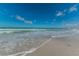 Beach scene showcasing gentle waves meeting a sandy shore under a bright blue sky with scattered clouds at 1700 Pass A Grille Way # 9, St Pete Beach, FL 33706