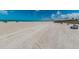 Expansive beach view with white sand, blue skies, and ocean waves, showcasing the natural beauty of the coastal setting at 1700 Pass A Grille Way # 9, St Pete Beach, FL 33706