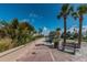 Brick walkway along a beach with palm trees and a bench at 1700 Pass A Grille Way # 9, St Pete Beach, FL 33706
