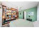 A cozy bedroom with a large bookcase and soothing green walls creates a relaxing atmosphere at 1700 Pass A Grille Way # 9, St Pete Beach, FL 33706
