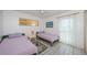 Bright bedroom features two twin beds, tile flooring, and a sliding glass door at 1700 Pass A Grille Way # 9, St Pete Beach, FL 33706