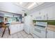 Bright kitchen with white cabinets and appliances, offering an open view into the living area at 1700 Pass A Grille Way # 9, St Pete Beach, FL 33706