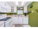 Charming kitchen featuring white appliances, cabinets, green accents, and nautical decor at 1700 Pass A Grille Way # 9, St Pete Beach, FL 33706