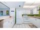 Bright kitchen featuring white appliances, cabinets, and a breakfast bar with an adjacent living area at 1700 Pass A Grille Way # 9, St Pete Beach, FL 33706