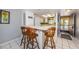 Bright kitchen featuring a breakfast bar, white cabinetry, and an open doorway leading to a beach view at 1700 Pass A Grille Way # 9, St Pete Beach, FL 33706