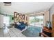 Open-concept living room with comfortable seating, a balcony, and a decorative bookshelf divider to the bedroom at 1700 Pass A Grille Way # 9, St Pete Beach, FL 33706