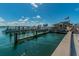 Picturesque waterfront marina featuring docks, boats, and a building with an American flag at 1700 Pass A Grille Way # 9, St Pete Beach, FL 33706
