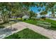 Well-maintained park featuring a walkway, lush lawn, mature trees, benches and picnic tables at 1700 Pass A Grille Way # 9, St Pete Beach, FL 33706