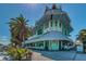 Unique two-story building in light green and blue with a palm tree in front at 1700 Pass A Grille Way # 9, St Pete Beach, FL 33706