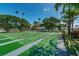 Open shuffleboard courts with surrounding trees and a clear blue sky, promoting active outdoor living at 1700 Pass A Grille Way # 9, St Pete Beach, FL 33706
