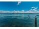Scenic view of calm blue waters with weathered wooden posts and a distant city skyline at 1700 Pass A Grille Way # 9, St Pete Beach, FL 33706