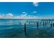 Calm blue water landscape featuring weathered wooden posts and a distant cityscape at 1700 Pass A Grille Way # 9, St Pete Beach, FL 33706