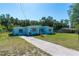 A light blue one-story home in a chain link fenced in yard at 17111 Mockingbird Ln, Lutz, FL 33548
