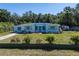 Home with well-maintained lawn and bushes and a green privacy wall at 17111 Mockingbird Ln, Lutz, FL 33548
