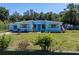 Charming blue single-story home with vibrant yellow shutter accents and a well-manicured front yard at 17111 Mockingbird Ln, Lutz, FL 33548