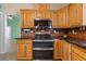 Kitchen with black cooktop, stainless oven, and wooden cabinets at 17111 Mockingbird Ln, Lutz, FL 33548