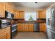 Eat-in kitchen with stainless steel appliances and wooden cabinets at 17111 Mockingbird Ln, Lutz, FL 33548