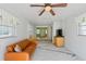 Cozy living room with ceiling fan, gray and white rug, and bright natural light at 17111 Mockingbird Ln, Lutz, FL 33548