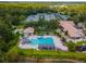 Aerial view showcases a community pool, tennis courts, clubhouse, and beautiful green landscaping at 17537 Fairmeadow Dr, Tampa, FL 33647