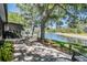 Outdoor patio with table and chairs overlooking a serene lake at 17537 Fairmeadow Dr, Tampa, FL 33647