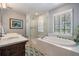 Bright bathroom featuring a double sink vanity, glass enclosed shower and soaking tub at 17537 Fairmeadow Dr, Tampa, FL 33647