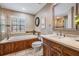 Bathroom with a soaking tub with wood paneling, travertine countertop vanity, and a framed mirror at 17537 Fairmeadow Dr, Tampa, FL 33647
