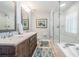 Bright bathroom featuring a double sink vanity with marble top, a glass enclosed shower and soaking tub at 17537 Fairmeadow Dr, Tampa, FL 33647