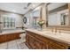Bathroom with a soaking tub with wood paneling, tile floors, and double travertine countertop vanities at 17537 Fairmeadow Dr, Tampa, FL 33647