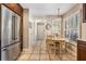 Kitchen with stainless steel refrigerator and an adjacent dining area with natural lighting and tile floors at 17537 Fairmeadow Dr, Tampa, FL 33647