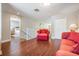 Relaxing living room area with a red sofa, hardwood floors, and open staircase to the second level at 17537 Fairmeadow Dr, Tampa, FL 33647