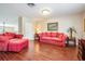 Inviting living room with red sofas, hardwood floors, and natural light creating a warm atmosphere at 17537 Fairmeadow Dr, Tampa, FL 33647