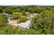 Aerial view showcasing home nestled within lush greenery, highlighting its gray roof and neighborhood setting at 1905 Oro Ct, Clearwater, FL 33764