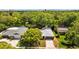 Overhead shot of home with manicured lawn, surrounded by dense trees, with a gray garage door at 1905 Oro Ct, Clearwater, FL 33764