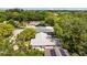 Birds-eye view of home with screened pool, surrounded by lush trees, other homes and mature landscaping at 1905 Oro Ct, Clearwater, FL 33764